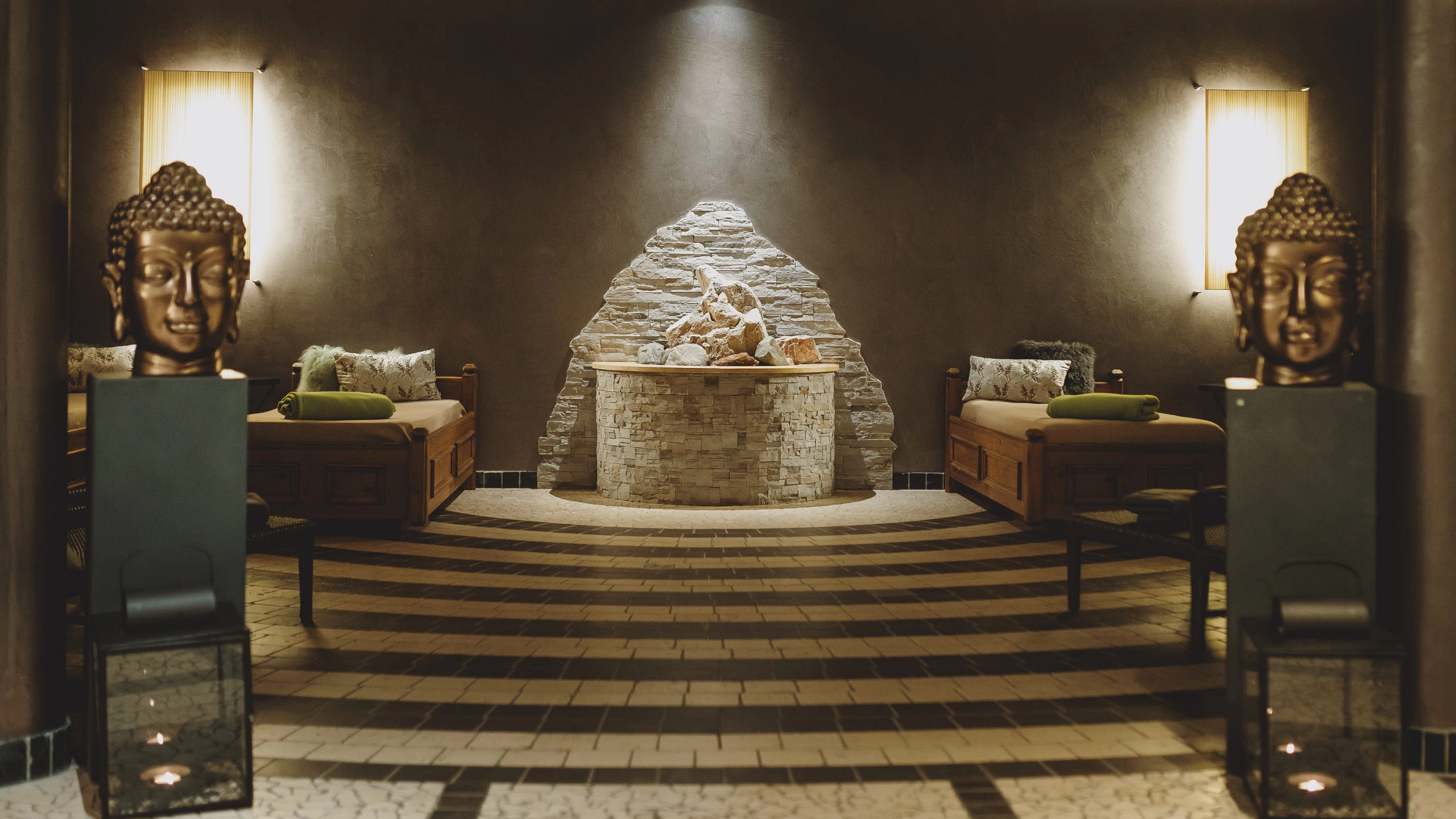 In einem Spa-Bereich mit Wasserstelle, Buddha-Statuen und Sitzgelegenheiten.