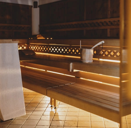 Holzsauna mit Bänken und Kelle auf dem Tisch