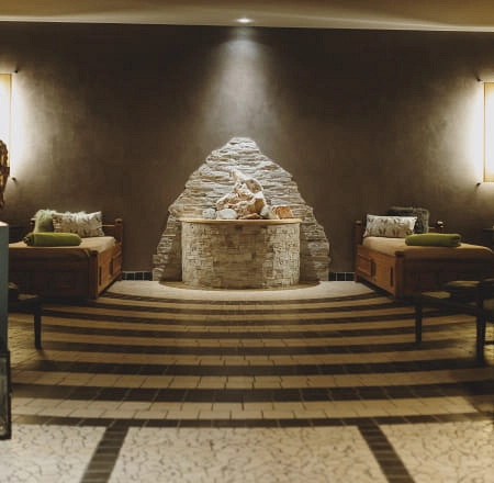Gemütliche Sitzbereiche mit Steinbrunnen und beleuchteten Wänden.