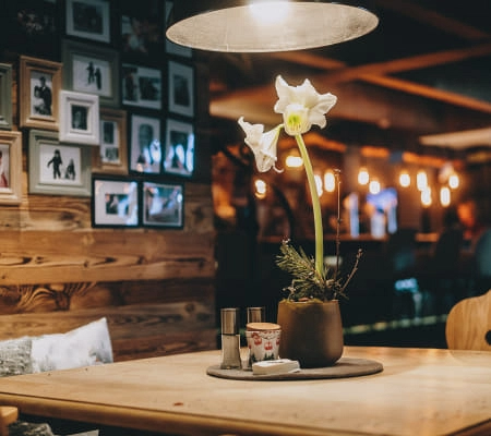 Blick auf einen Tisch mit dekorativer Blume und Bildern an der Wand