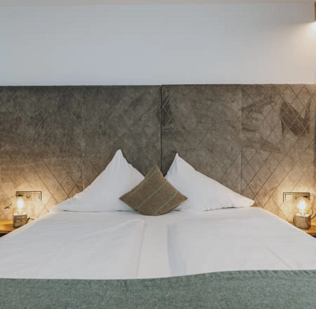 Detailansicht eines Schlafzimmers mit einem Bett und modernen Nachttischen