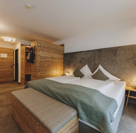 Modernes Zimmer mit Holzdetails, Bett und Sitzbank.