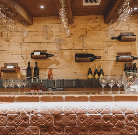 Weinlounge mit Regalen voller Weinflaschen und Gläsern an der Bar
