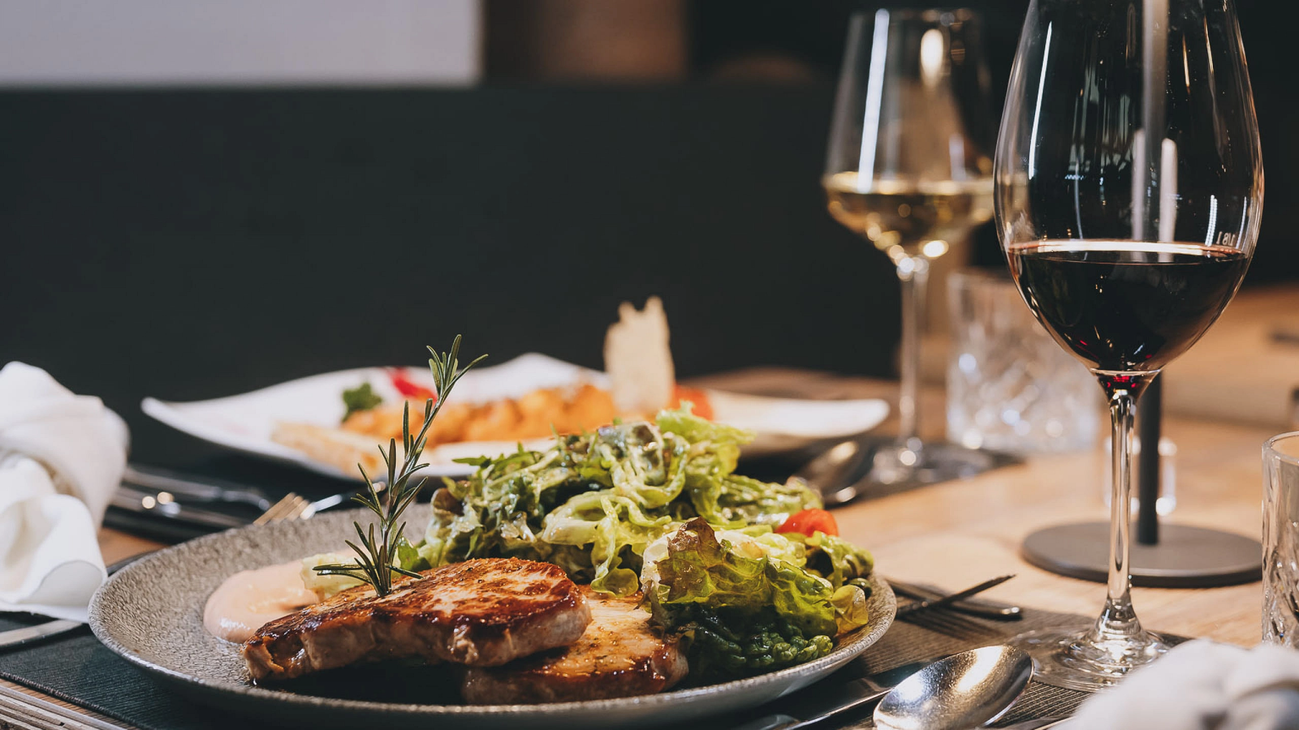 Ein Teller mit gegrilltem Fleisch und Salat in einem Restaurant.