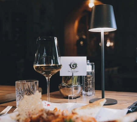 Elegantes Restaurant mit Wein, Wasser und Menükarte.