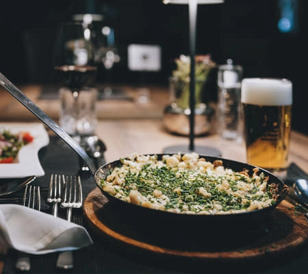 Ein Gericht mit Kräutern, Bier und Wein auf einem Tisch.
