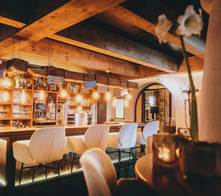 Holzverkleidete Bar mit Hockern und warmem Licht