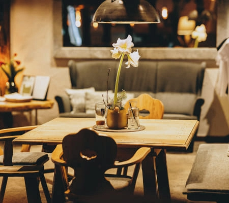 Gemütliche Bar mit Tisch, Stühlen und Blumendekoration