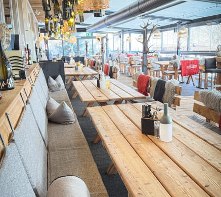 Gemütliches Restaurantinterieur mit Holztischen und Sitzgelegenheiten