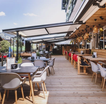 Terrasse mit Holzmöbeln und Sonnenschirmen in einem Restaurant