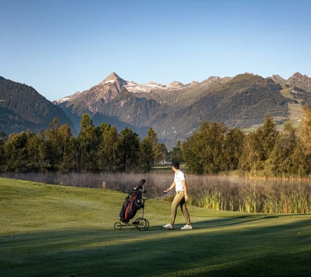 Golfspieler auf einem Platz in Zell am See mit Bergen im Hintergrund