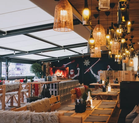 Gemütliche Terrasse mit warmen Lichtern und rustikalen Möbeln.