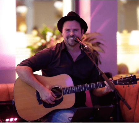 Musiker mit Gitarre, der in einem Veranstaltungsort auftritt.