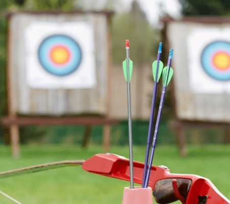Pfeile und Bogen vor Zielscheiben im Freien